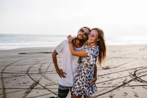 Feliz pareja abrazándose en la playa en bali, indonesia - foto de stock