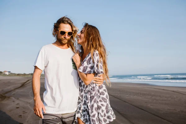 Sonriente pareja abrazándose en la orilla del mar en bali, indonesia - foto de stock