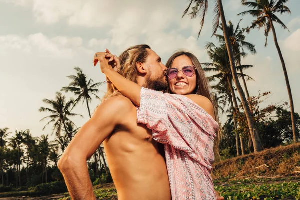 Vista laterale di coppia sorridente che si abbraccia sulla spiaggia di bali, indonesia — Foto stock