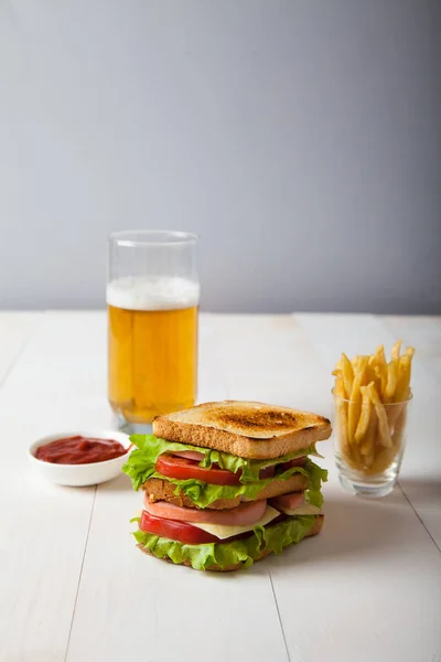 Sándwich con cerveza, papas fritas y salsa en bac de madera blanca — Foto de Stock