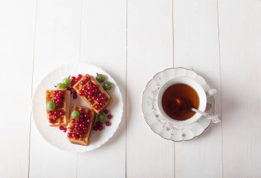 Kuş üzümü ve bir fincan çay ile Viyana waffle masaya standı