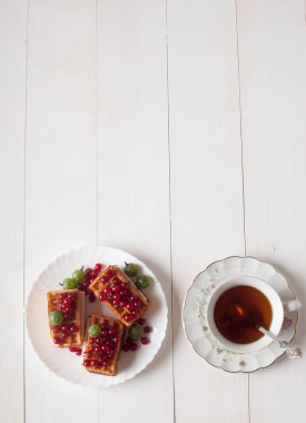 Kuş üzümü ve bir fincan çay ile Viyana waffle masaya standı