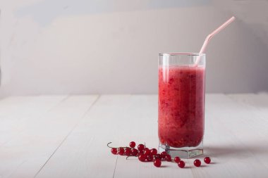bir bardak taze smoothies beyaz bir masada duruyor