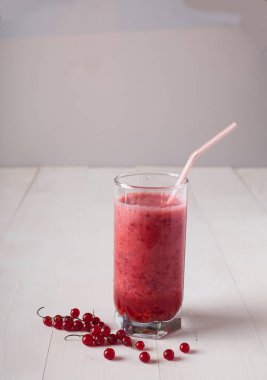 bir bardak taze smoothies beyaz bir masada duruyor