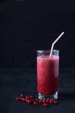 bir bardak taze smoothies siyah bir masada duruyor