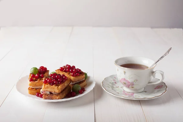 维也纳人的华夫饼与葡萄干和一杯茶站在桌上 — 图库照片