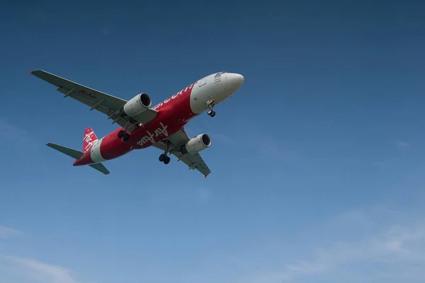 舞瀬で着陸のため青い空に赤い飛行機を引き継ぐ — ストック写真