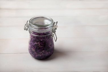 bir keten napki bir kapak ile cam bir kavanozda fermente kırmızı lahana