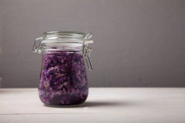 gri bir backgr bir kapak ile cam bir kavanozda fermente kırmızı lahana