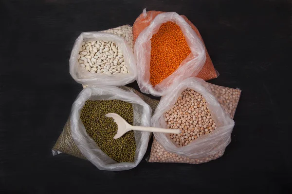 White beans, red lentils, peas and mung bean in plastic bags on — Stock Photo, Image