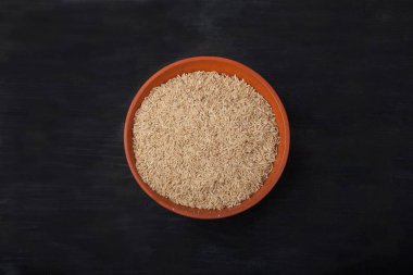 siyah arka plan üzerinde toprak içinde cilasız pirinç. Superfood