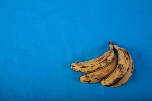Moche bananes trop mûres sur un fond bleu. Gros plan . — Photo