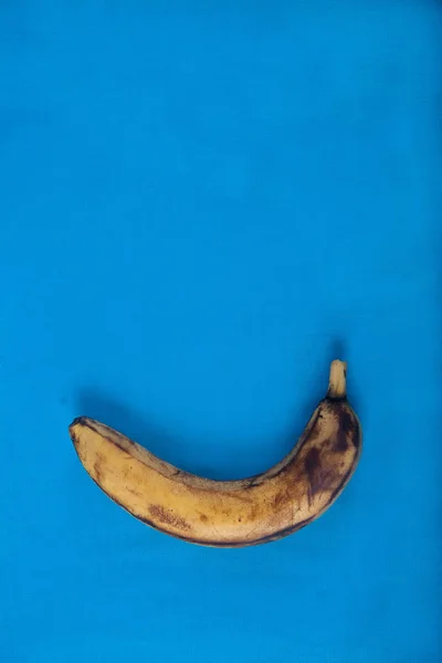 Mavi arka planda çirkin olgunlaşmış muz. Close.