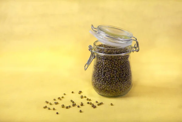 Mung bean in a jar on a yellow background. Copy spaes. — Stock Photo, Image