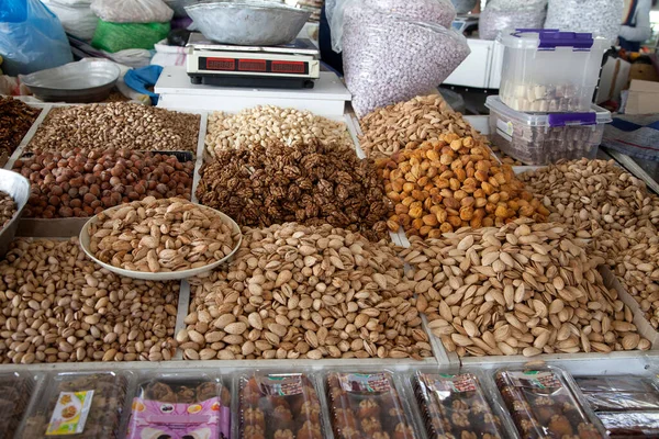 Różne orzechy i suszone morele obok łuski w Chorsu Bazaar w Taszkencie, Uzbekistan. 29.04.2019 — Zdjęcie stockowe