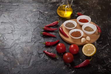 Harissa için yer baharatları, domates, limon, siyah arka plandaki ahşap tezgahta duran yağ. ögeleri kopyala