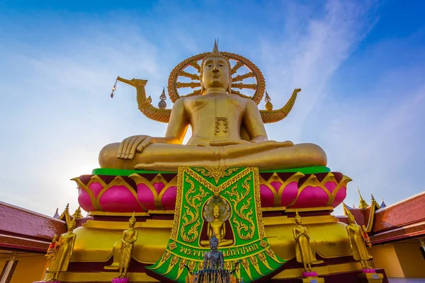 Large gold buddha statue in a sitting position under the blue sky at Big Buddha Temple is a famous tourist destination of Koh Samui island, Surat Thani province, Thailand