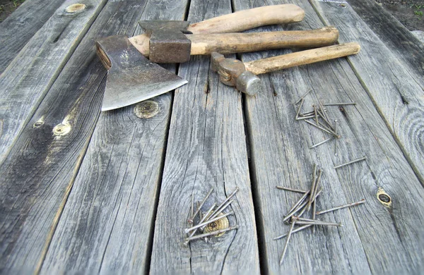 Deux haches, marteau et clous reposent sur des planches en bois — Photo