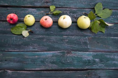 Olgun elma yeşil yaprakları ile ahşap bir arka plan üzerinde yalan