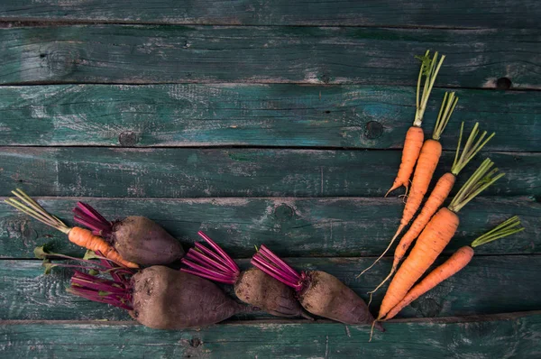 Barbabietola da fattoria fresca e carote su uno sfondo di legno — Foto Stock