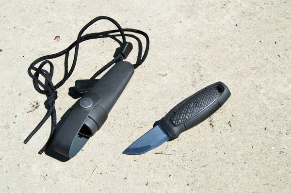 Jaktkniv med svart plasthandtag ligger på sanden — Stockfoto