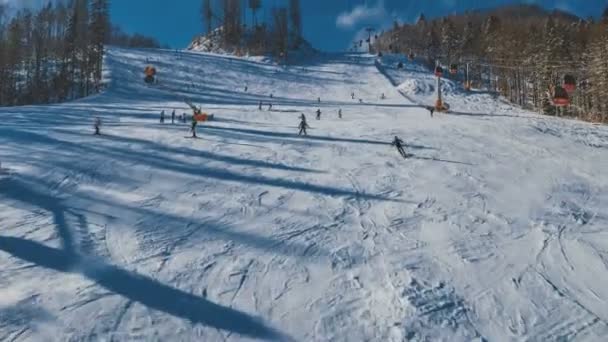 滑雪者和滑雪在斜坡上滑动的空中镜头 从无人驾驶飞机上射出的斜坡上的飞行 — 图库视频影像