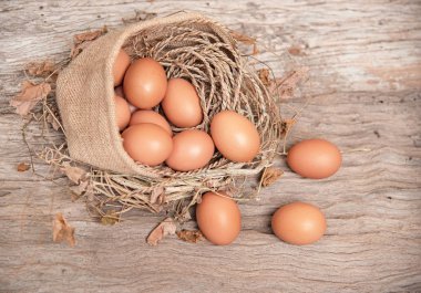 Kenevir çantaya koy ve Ahşap ahşap tahta, vintage ve sanat zil sesi üzerinde kurutulmuş yaprakları ile etrafında bulanık ışık kapak closeup grup çiğ yumurta.