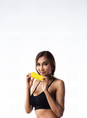 Egzersiz elbiseli Bayan holding sarı Mısır gülümseme ve mutlu yüz onun elinde, hazırlamak yemek, sağlıklı yemek, diyet için iyi ve yaşam için iyi