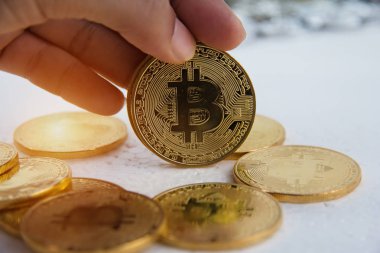 Closeup altın bitcoin insan eliyle, bulanık hafif tasarım arka plan tutuyordu.