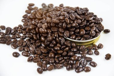 Beyaz arka plan, etrafında bulanık ışık koymak kavrulmuş kahve çekirdekleri closeup Grup.