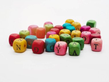 In selective focus of wooden dice , T alphabet , at the right side of colorful dice group,blurry light around. clipart