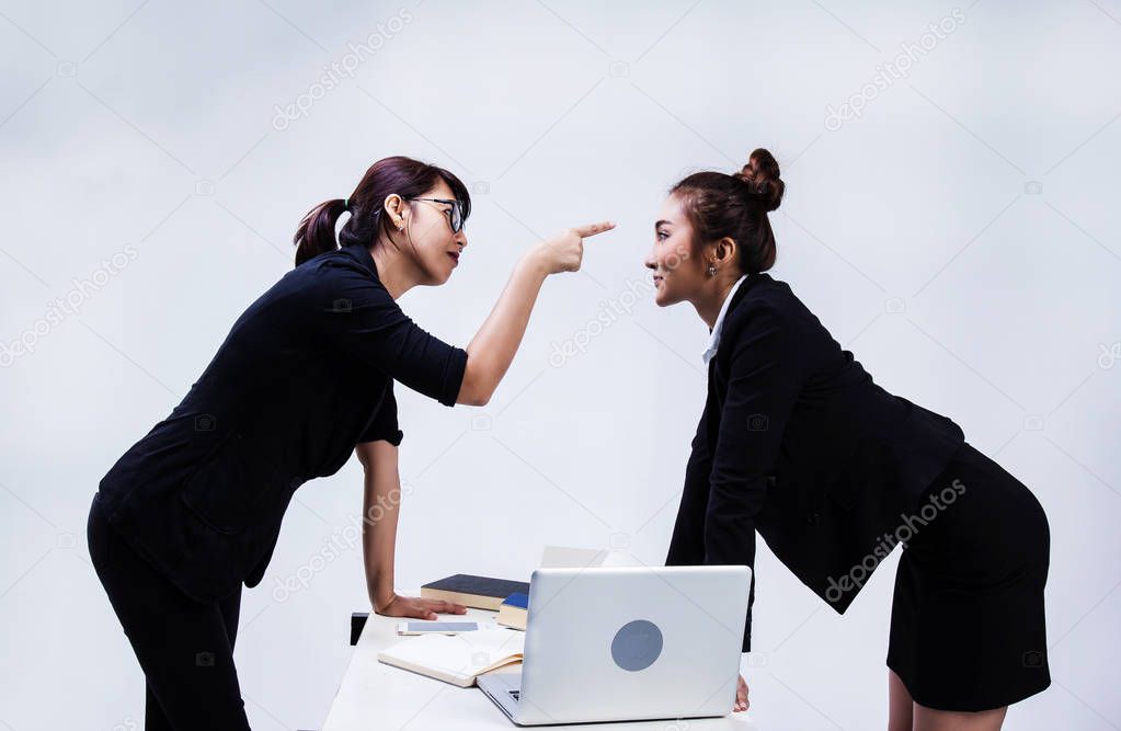 The business women are fighting together ,the lady at left side is point to face of lady at right side,cannot deal about paper work ,the business negotiations failed,
