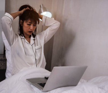 Hanımefendinin seçici odak noktasında stres ve denenmiş his, önünde dizüstü bilgisayar, çok çalışma, ciddi duygu, korku bozukluğu, mutsuz duygu, bulanık ışık tasarımı arka plan.