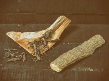 Kuru çay yaprakları seçici odak içinde ahşap herb, bulanık ahşap ot çubuğa grunge yüzey ahşap masa, yanında klasik eski film tasarımı, vintage ve sanat sesi, bulanık açık renkli koymak.