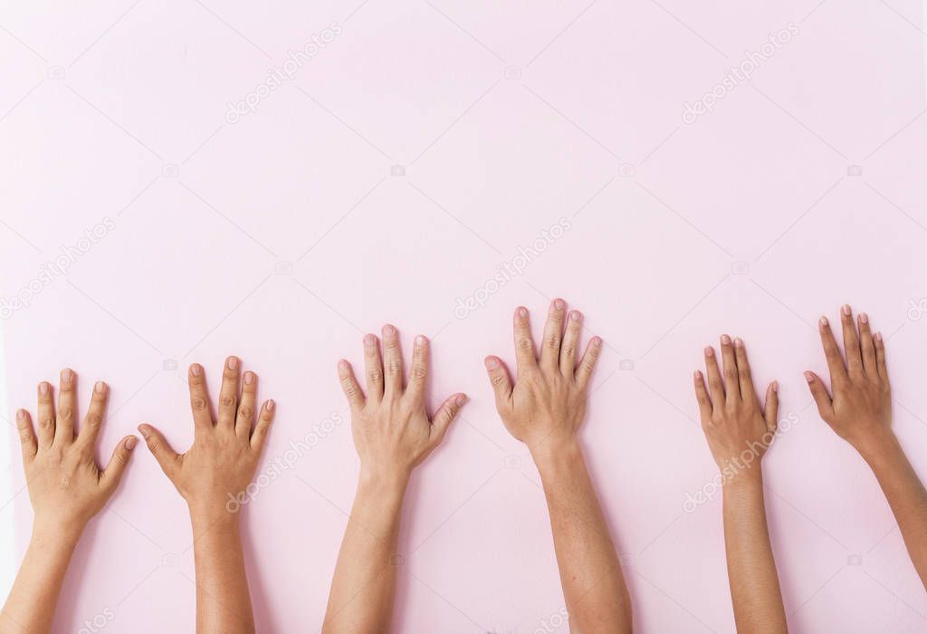 The human hands touch on pink pastel background,the hand sign of togetherness,partnership of human,union,the symbol of successful and cheerful
