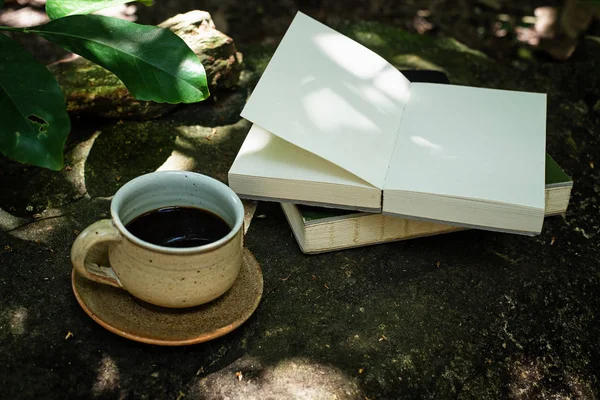 黒いコーヒーカップは 公園で 0ペンドの本の横に置かれた — ストック写真