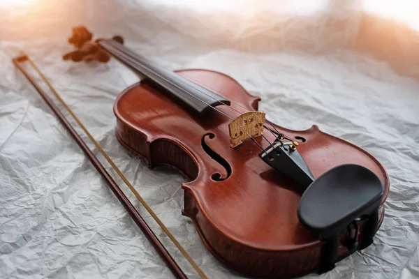 木製のバイオリンと弓は グランジ表面の背景 暖かい光のトーン 周りのぼやけた光に置きます — ストック写真