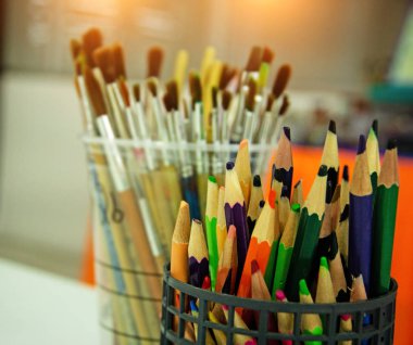Plastik kutuda kullanılan renkli kalem seçici odak, sıcak ışık tonu, bulanık ışık etrafında