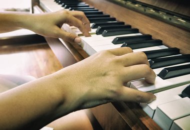 İnsan elinin abstrct sanat tasarım arka plan piyano tuşu, sıcak ışık tonu, bulanık ışık etrafında basıyor