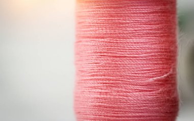 Arka planda pembe iplik dokusucloseup, iğne, zanaat, dikiş ve terzilik kavramı, bulanık ışık tasarım arka plan