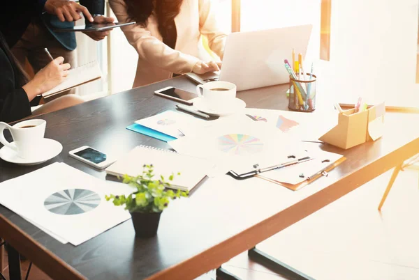 The blurry light design background of business workers are working at office hour,business paper chart and office desk,warm light tone