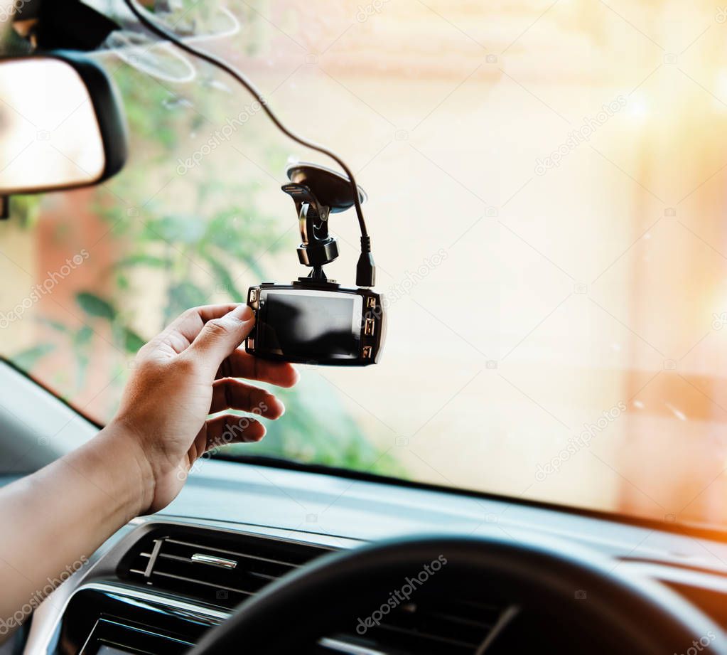 In selective focus of the human hand is touching car camera,before driving,for checking system of the camera recording ,the technology for car user,warm light tone,blurry light around