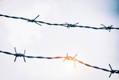 Uzun zamandır kullanılan demir, diken ve pasdan yapılmış dikenli tel çit