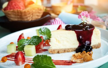 Beyaz çanak tepesi ahududu ile Closeup Peynir kek, bulanık Lightaround