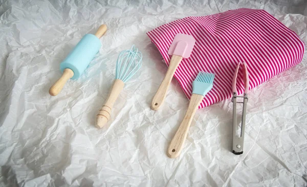The mini silicone spatula,brush,egg whisk,rolling pin and nylon food tongs put on grunge surface background,the baking set