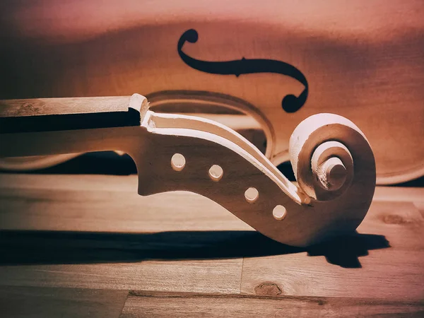 生のバイオリンネックの選択的な焦点で ペグホール ペグボックス 木製のボード上のスクロール ヴィンテージとアートトーン ぼやけた光のデザインの背景 — ストック写真