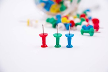 Beyaz arka plana üç itme pimi, bulanık ışık