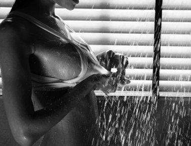 Duş alan çıplak kadın, güzellik vücuduna parlayan güneş ışığının yansıması, etrafa su sıçratma,seksi model poz.siyah ve beyaz tonu