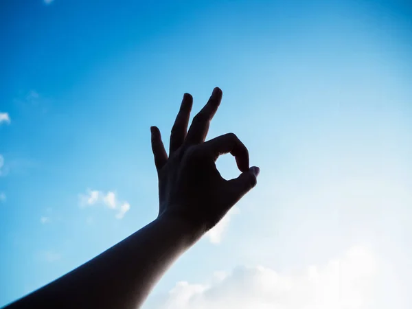 The silhouette hand sign reach to the sky background, finger touch together,symbol of success,positive sign
