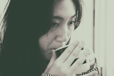 Kahve içen güzel kadının bulanık ışık tasarım arka plan, klasik eski film tonu, vintage ve sanat tarzı